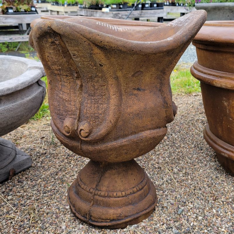 An upright Rialto Urn planter with decorative scroll designs and rounded base