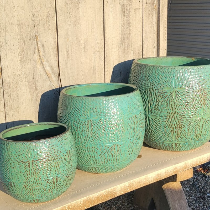 A trio of rounded Sand Dollar Planters; all are finished in a translucent turquoise glaze over earthenware. The planters are sized medium, large, and extra large.