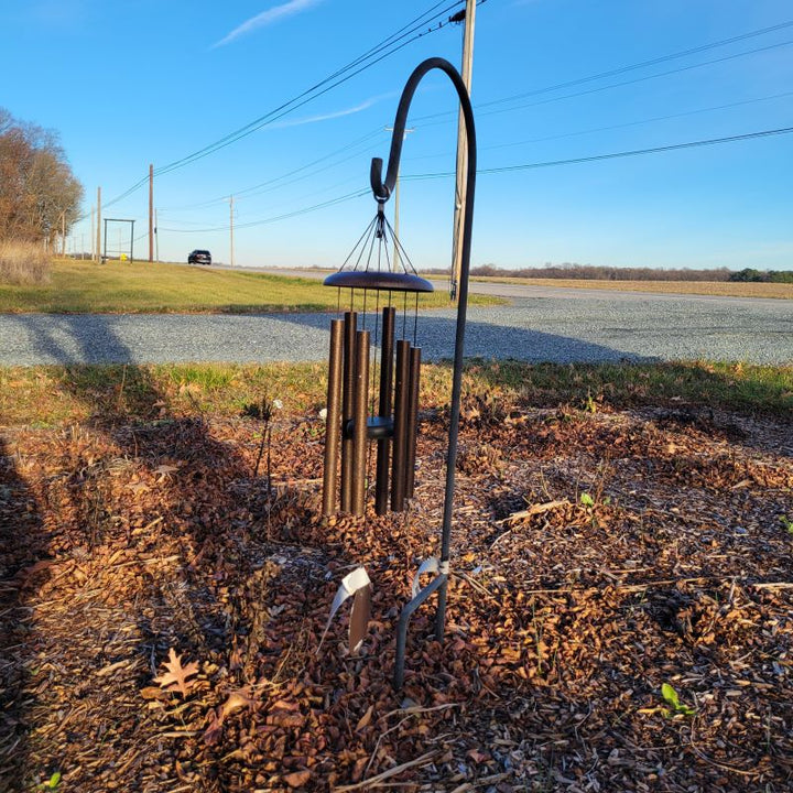 A 48" Shepherd's Hook in using, holding a set of copper metallic windchimes.