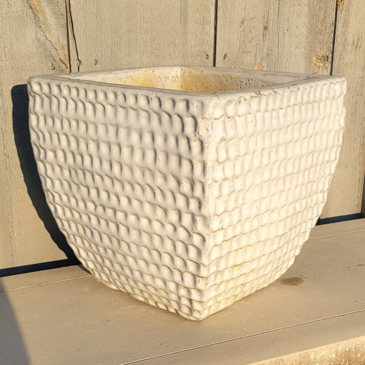 A rounded Square Dimple Planter with bowed walls, decorated with a regularly spaced dimple design over its entire exterior. The planter is finished with a gloss white glaze.