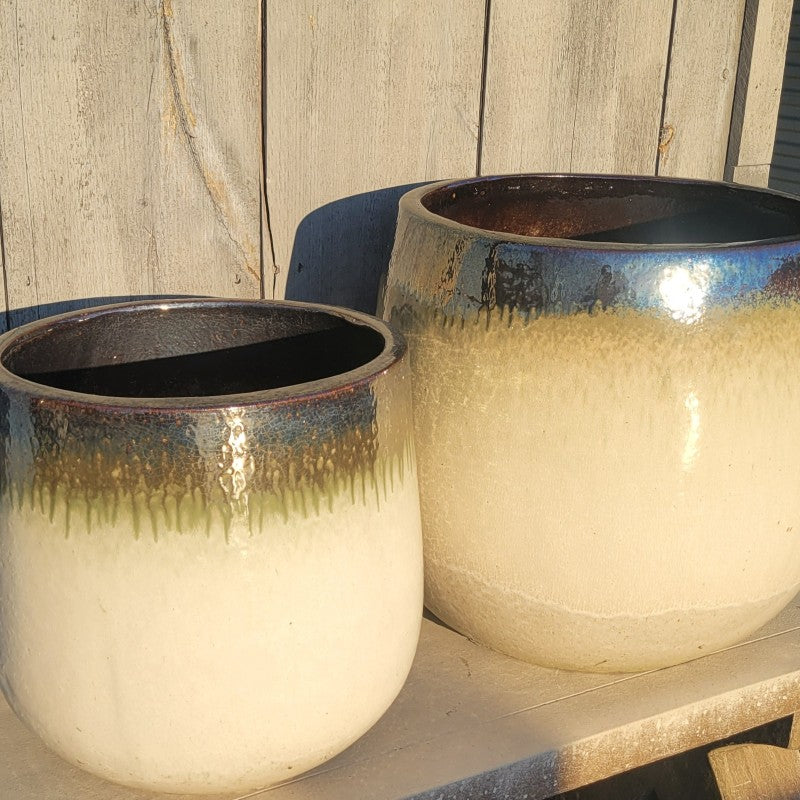 A pair of cream white, olive green, and mirror black Tall Oval Planters, one smaller and one larger.