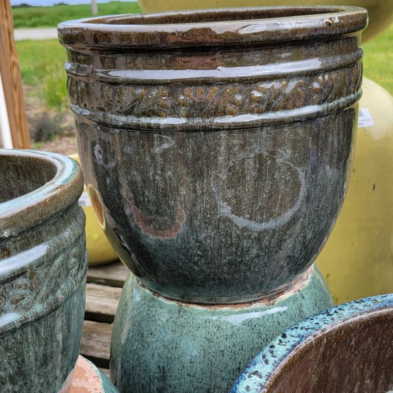 A close-up photo of the natural green glaze and encircling botanical tendril design of the Tendril Planter