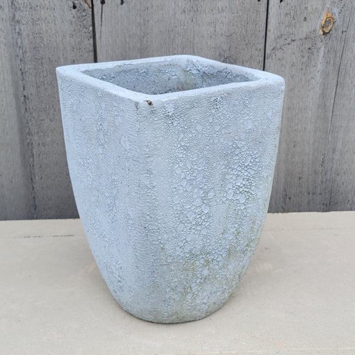 An upright rounded square Teo Planter with a narrow base; finished with a white-gray coral or pumice-stone glaze.