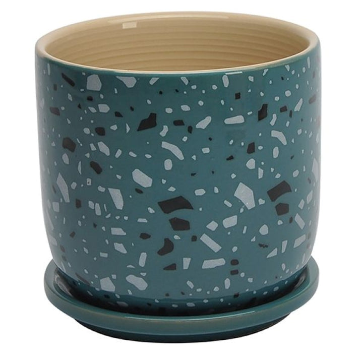 A stock photo of a round, straight-walled planter with built-in saucer; the planter's plain sides are decorated with a dark turquoise-blue faux-terrazzo style glaze.