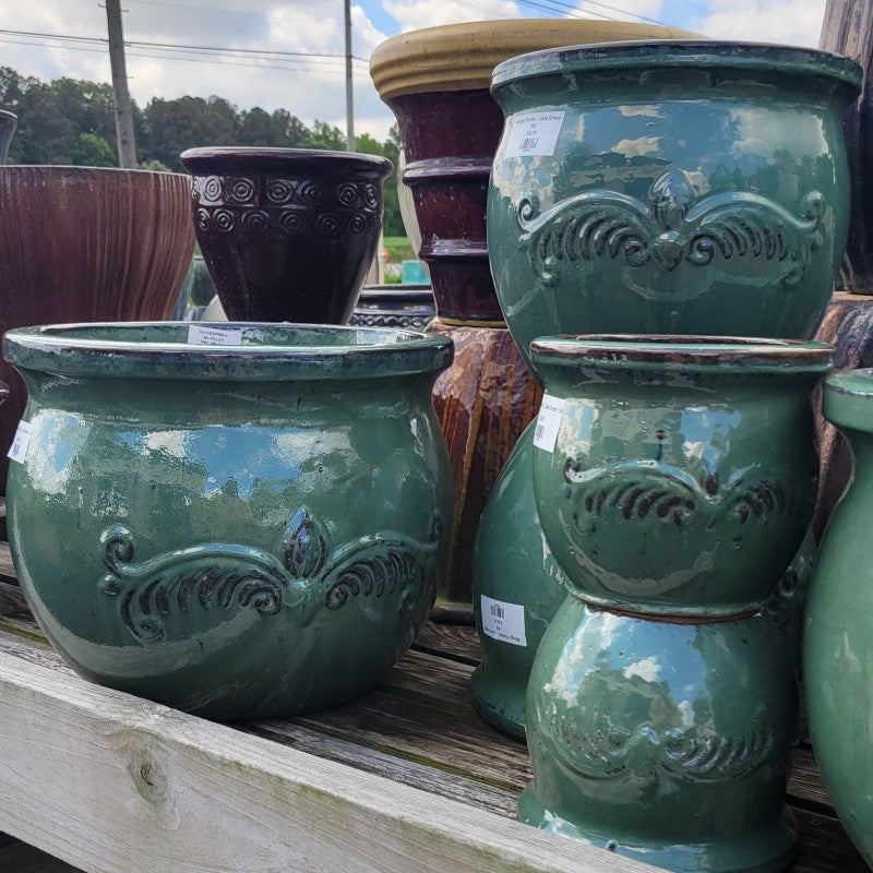 A collection of rounded, glossy Wings Planters, finished in jade-green glaze with winged heart design